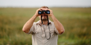 man looking through binoculars